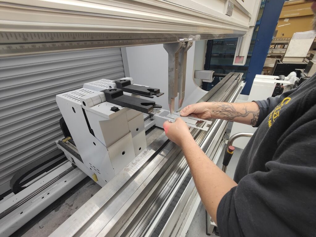 Opérateur travaillant sur une plieuse métal.