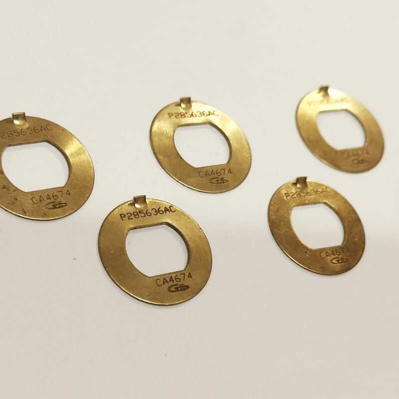 Rondelles métalliques en laiton gravées et découpées au laser – pièces ovales de précision avec marquage laser pour traçabilité industrielle.